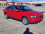 2007 Volvo S40 2.4i sedan in red color parked, features a manual transmission and shows signs of wear.