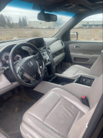Interior view of a 2014 Honda Pilot EX-L with leather seats and modern dashboard.