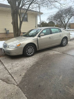2009 Buick Lucerne CXL FWD parked on a residential street, showcasing its neutral color and new tires.