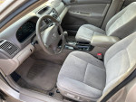 Interior view of a well-maintained 2004 Toyota Camry with clean upholstery and functional controls.