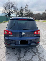 Rear view of a blue 2011 Volkswagen Tiguan SEL 4Motion in a parking lot, showcasing its sleek design.