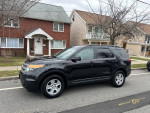 2014 Ford Explorer XLT FWD parked on the street, showcasing its black exterior and stylish design.