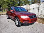2005 Volkswagen Touareg V6 SUV in red parked outside with clean exterior and alloy wheels
