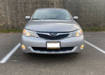 Front view of a 2009 Subaru Impreza Outback Sport AWD in silver color with headlights on