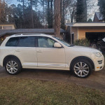 2010 Volkswagen Touareg in white, showcasing stylish design and Pirelli tires, parked in driveway.