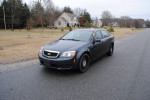 2014 Chevrolet Caprice PPV police package in dark color, low mileage, parked on street with houses in background