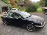 2003 Jaguar X-Type black sedan with manual transmission, four doors, parked in driveway.