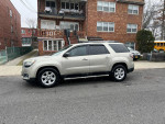 Side view of a 2013 GMC Acadia SLE in good condition parked on a street, showcasing its spacious design for 7 passengers.