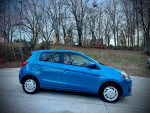 2015 Mitsubishi Mirage in blue, parked in a scenic spot, showing its well-maintained exterior and low mileage.