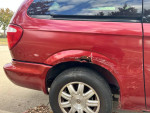 Close-up of a 2005 Chrysler Town & Country with visible rust and damage on the rear panel