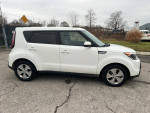 2016 Kia Soul in white, showcasing its sleek design and alloy wheels on a paved road.