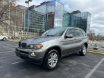 2006 BMW X5 3.0i AWD in grey parked in a city environment, showcasing its sleek design and features.