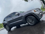 Gray Jeep Grand Cherokee Trailhawk parked, showcasing its stylish design and off-road capability.
