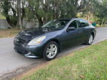 2011 Infiniti G25 x with clean Carfax parked on a tree-lined street, showcasing its sleek design.