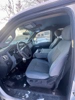 Interior view of a 2014 Ford F250 Super Duty, spacious seats with controls and ample legroom.