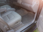 Interior view of a well-maintained 1999 Chevrolet Suburban with leather seats and spacious layout.