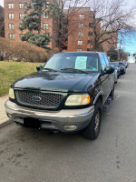 2002 Ford F150 Super Crew Cab in green, parked, showcasing its 4WD capabilities and clean title.