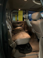Interior of a 2002 Ford F150 Super Crew Cab with beige leather seats and spacious layout.