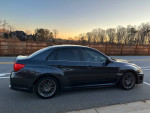 2014 Subaru Impreza WRX sedan in excellent condition, showing off its sleek profile and aftermarket wheels.