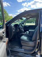 Interior view of a 2021 GMC Sierra 1500 Denali with black leather seats and modern dashboard features.