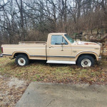 1984 Ford F250 classic truck with solid body, in need of repair, parked on grass