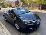 2016 Buick Cascada convertible parked on the street with the top down, showcasing its sleek design.