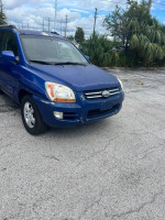 2006 Kia Sportage with 55,000 miles, showing original faded paint and good tires, ideal for daily driving.