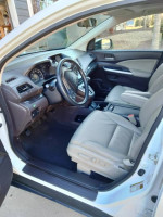 Interior view of a 2014 Honda CRV EX-L AWD with beige leather seats and modern dashboard features.