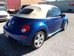 2007 Volkswagen Beetle convertible in blue with a soft top, parked in a used car lot.