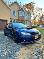 2013 Subaru WRX Impreza in blue, showcasing upgrades and parked in a residential area.