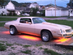 1980 Chevrolet Camaro with orange underglow lights parked outside, showcasing its classic design and restored features.