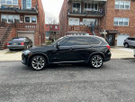 2016 BMW X5 xDrive parked in urban environment, showcasing sleek design and luxury features.