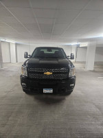 Front view of a 2014 Chevrolet Silverado 2500HD LTZ 4WD in a parking garage, showcasing its sleek design.
