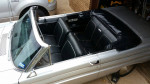 Interior view of a 1964 Ford Falcon Convertible with black seats and a silver body.