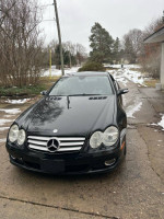 2008 Mercedes-Benz SL 550 convertible, black exterior, parked on a snowy street, needing repairs.