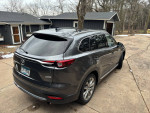 2019 Mazda CX-9 Grand Touring FWD parked in front of a house with wooded surroundings.