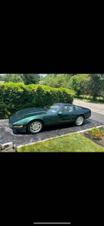 1994 Chevrolet Corvette in green color, parked, with 76,000 original miles, well-maintained and in good condition.