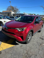 2018 red Toyota RAV4 parked, features 137,000 miles, available for sale with title in hand.