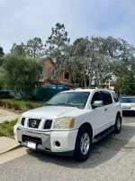 White Nissan Armada parked on the street, showcasing pristine condition and spacious design.