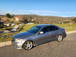 2008 Mercedes-Benz C300 luxury sedan in excellent condition parked on a scenic road with hills in the background.