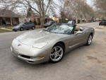 2001 Chevrolet Corvette C5 Convertible in Pewter Metallic parked on a street, showcasing its sleek design and chrome wheels.