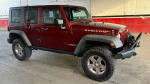 2010 Jeep Rubicon Unlimited in red, equipped with remote start and towing setup, available for sale.