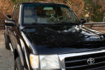 1998 Toyota Tacoma SR5 4WD Extended Cab with V6 engine, black exterior, parked in a scenic area