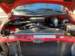 Dodge Ram 1500 V8 engine bay showcasing clean components and low mileage with a tow hitch.
