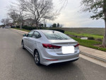 Silver 2018 Hyundai Elantra SEL parked on a street, showcasing its sleek design and surroundings.