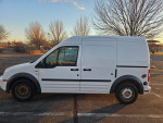 White cargo van parked in parking lot, ideal for contractors and camping trips, averaging 28 MPG highway.
