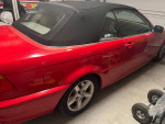 2003 BMW 3 Series 325Ci convertible in red, showcasing clean lines and typical wear, ready for sunny drives.