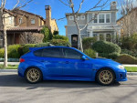 2013 Subaru Impreza WRX Hatchback in blue parked outside a house, featuring gold wheels and excellent condition.