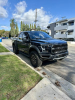 2020 Ford F-150 Raptor SuperCab parked on the street, showcasing its sleek design and excellent condition.