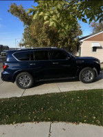 2020 Infiniti QX80 SUV parked on driveway, showcasing its sleek design and 4WD capabilities.